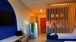 A modern hotel room with a desk, a bed, and a seating area. - Sabará Flats (Paraty)