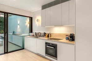 Una cocina moderna con horno integrado, cafetera y pileta.