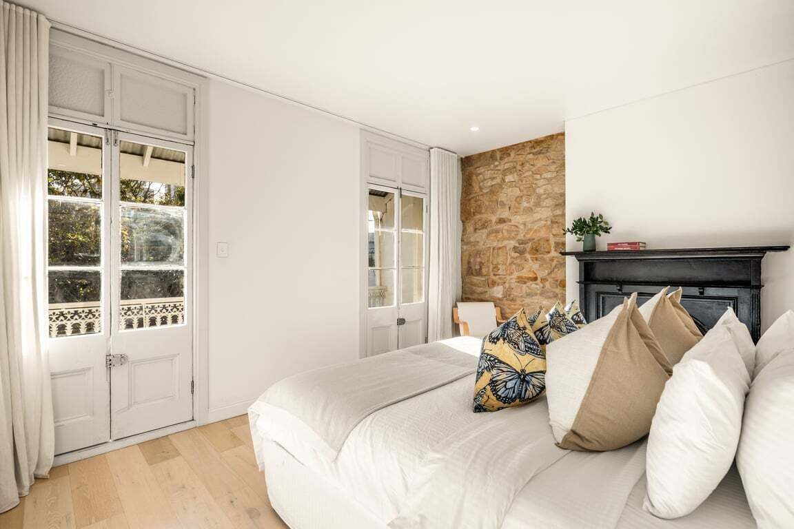 A bedroom with a bed, a fireplace, and a stone wall.