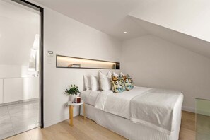 A modern bedroom with a bed, bedside table, and a wall-mounted shelf. - Palmer Darlinghurst - Stunning Terrace Home (Darlinghurst)