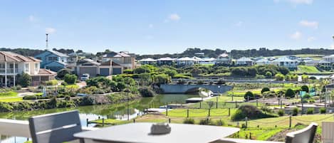 Vista de una zona residencial con casas, un cuerpo de agua y un puente.