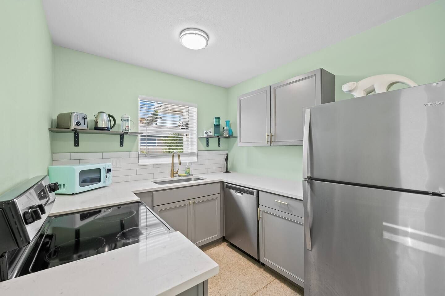 A kitchen with a dishwasher, a microwave, a sink, and a refrigerator.