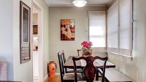 A dining area with a table, chairs, and a vase with flowers. - Vin Rouge 51 by Avantstay Sleeps 8 + Hillside Deck + Ping Pong 15-min Walk to Downtown (Paso Robles)