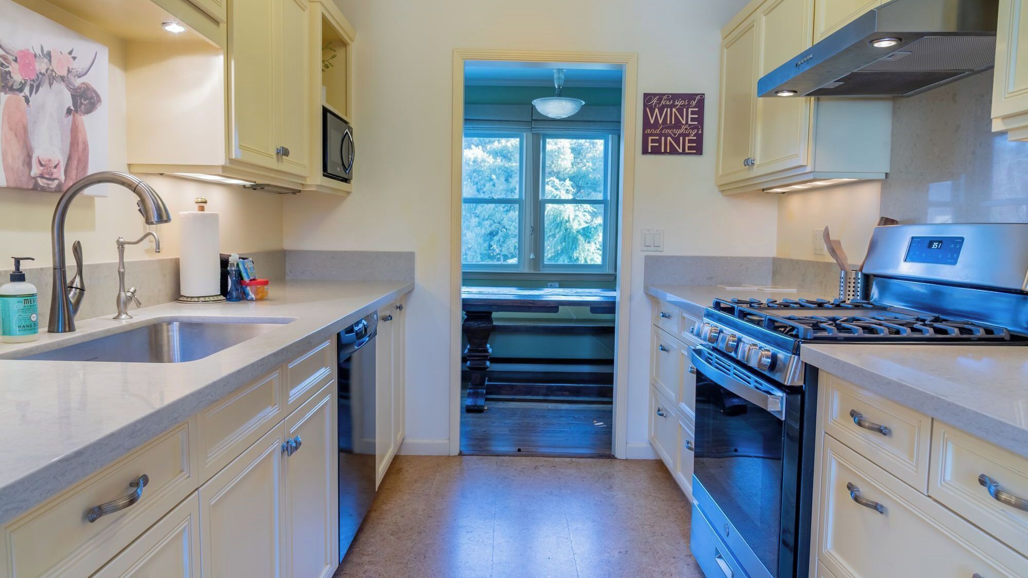 A kitchen with a sink, stove, and cabinets.