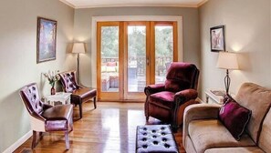 A living room with a sofa, armchairs, a coffee table, and a fireplace. There is a sliding glass door leading to an outdoor area. - Vin Rouge 51 by Avantstay Sleeps 8 + Hillside Deck + Ping Pong 15-min Walk to Downtown (Paso Robles)