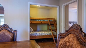 A room with a bunk bed, a wooden table, and two chairs. - Merry Hill by Avantstay Pool + BBQ + Chef's Kitchen Downtown Paso Robles (Paso Robles)