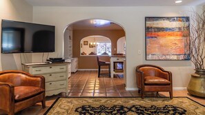 A living room with a flat-screen TV, leather chairs, a patterned rug, and a large abstract painting. - Merry Hill by Avantstay Pool + BBQ + Chef's Kitchen Downtown Paso Robles (Paso Robles)