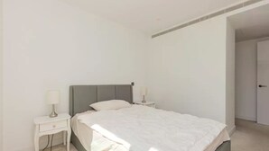 Ein Schlafzimmer mit einem Bett, zwei Nachttischen und einer Tür.