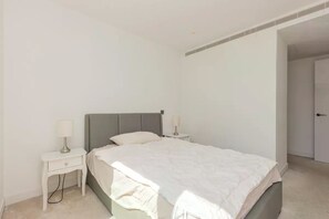 Ein Schlafzimmer mit einem Bett, zwei Nachttischen und einer Tür.