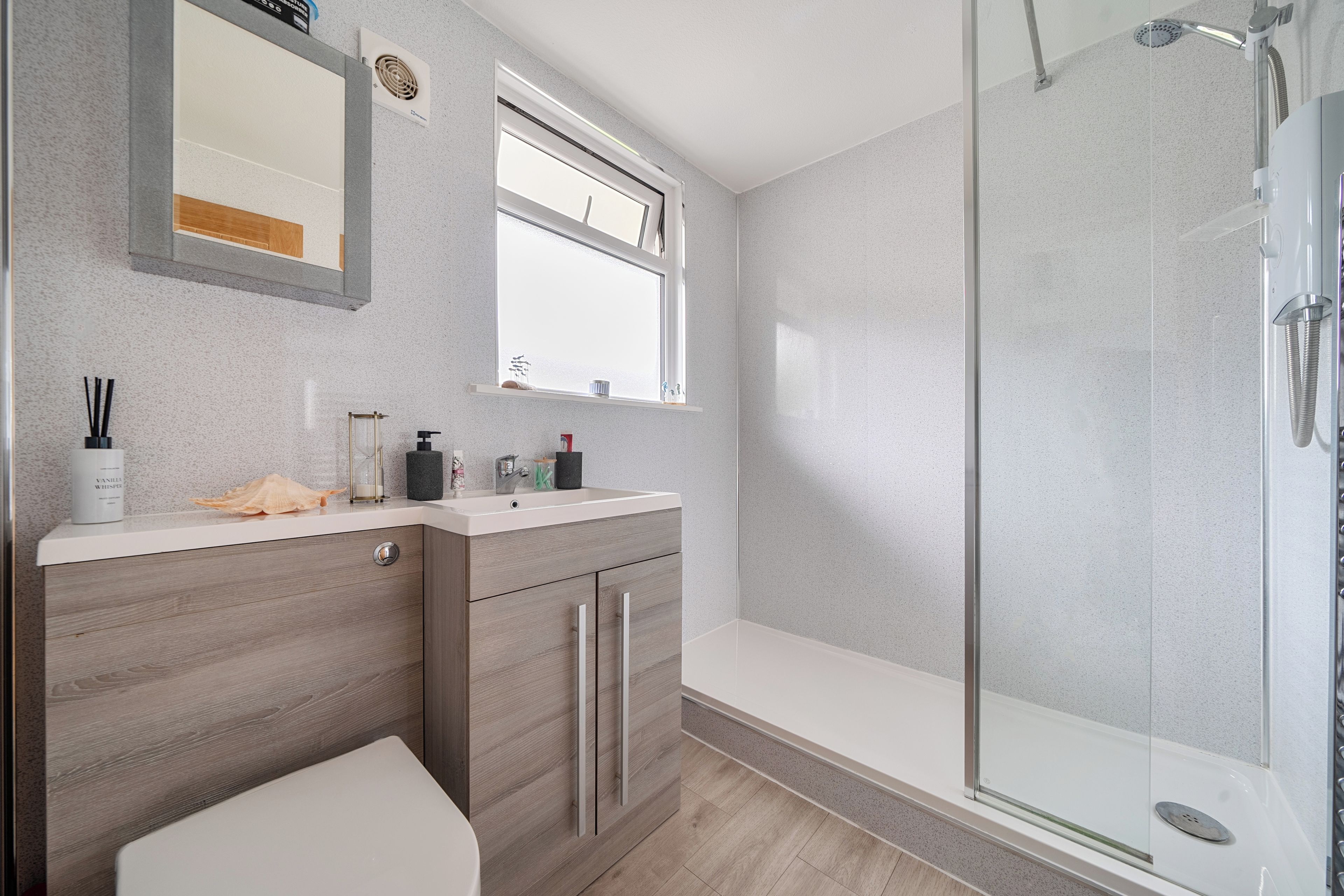 Ein modernes Badezimmer mit Dusche, Toilette und Waschtisch mit Spiegel.