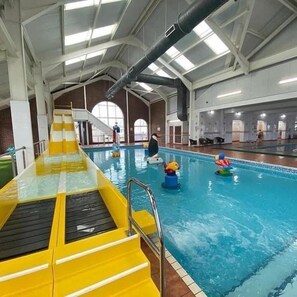 An indoor swimming pool with a yellow slide, a diving board, and a lifeguard stand. - Coastal Caravan at Lyons Robin Hood, Rhyl (Rhyl)