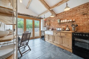 A kitchen with wooden cabinets, a black stove, and a dining area with a table and chairs.