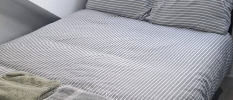 Tabla de planchar con plancha, wifi y ropa de cama