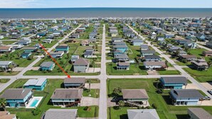Un quartiere residenziale con case, una piscina e vista sull'oceano.