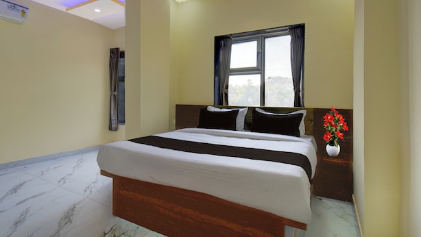 A bedroom with a bed, a window with curtains, a ceiling fan, and a wall-mounted air conditioner. - Super Collection O MIDC Pimpari Pune (Pune)