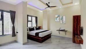 A modern bedroom with a bed, a ceiling fan, a window, and a wall-mounted TV. - Super Collection O MIDC Pimpari Pune (Pune)