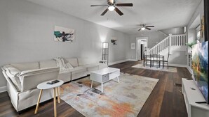 A spacious living room with a sofa, coffee table, and artwork on the walls.