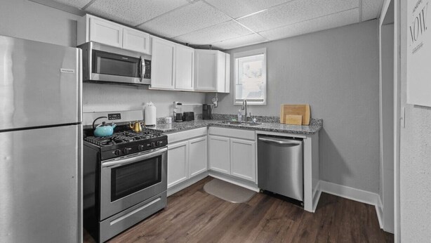 A compact kitchen with a refrigerator, microwave, stove, oven, and dishwasher.