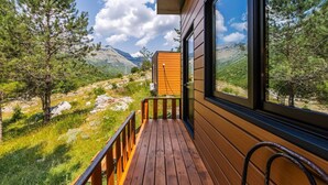 Una terraza de madera con vistas a un paisaje montañoso.