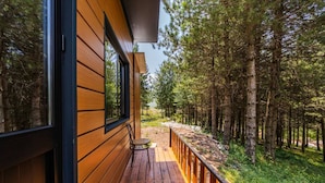 A wooden deck with a view of a forest.