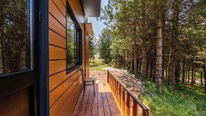 Une terrasse en bois avec vue sur une forêt.