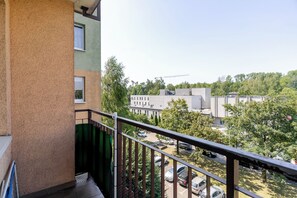 A balcony with a view of a parking lot and buildings. - Park Śląski Cozy Apartment (Katowice)