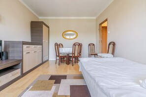 Un dormitorio con cama, escritorio, silla y mesa de comedor.