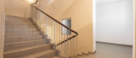 A staircase with a handrail leading to a landing.