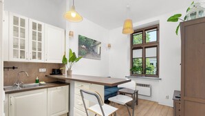 Eine moderne Küche mit weißen Schränken, einer eingebauten Spüle und einem Fenster mit Blick auf Grünflächen.