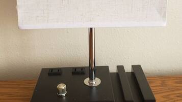 A table lamp with a rectangular shade on a black base with a brand name.