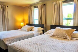 Une chambre d’hôtel avec deux lits, une table de chevet et une lampe.