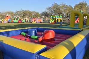 Un área de juegos inflable con diversas estructuras, incluyendo toboganes y elementos para escalar.