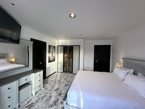 A hotel room with a bed, a desk, a wardrobe, and a door. - Sunset Beach Resort Marina Spa (Al Khobar)