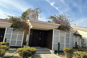 A residential building with a dark entrance door, white lattice panels, and a number '322' sign. - Sunset Beach Resort Marina Spa (Al Khobar)