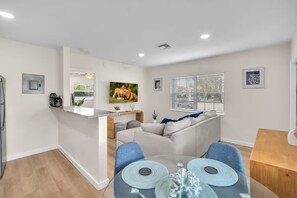 A modern living space with a kitchen area, dining table, and seating. - THE SEA MIST (Lauderdale-by-the-Sea)