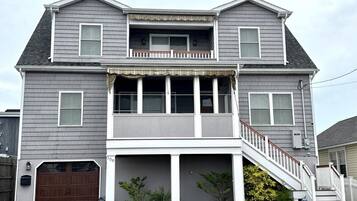 A two-story house with a front porch, a garage, and a staircase leading to the upper level.