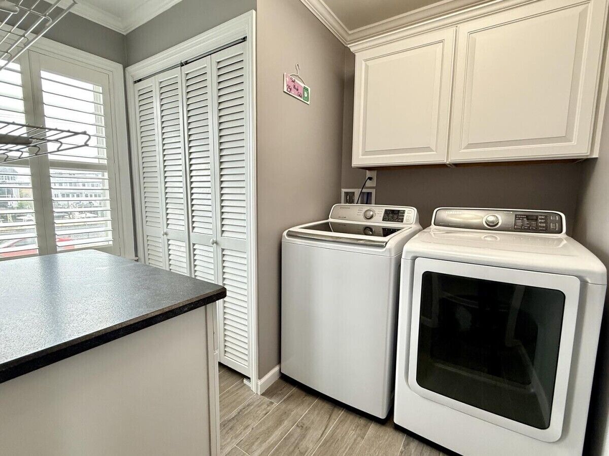 A laundry room with a washing machine, dryer, and a drying rack.