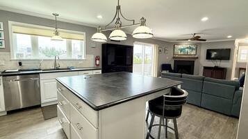 A modern kitchen with a central island, stainless steel appliances, and pendant lighting.