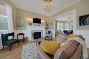 A living room with a fireplace, sofa, and television.