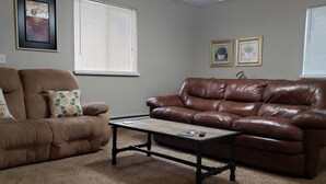 A living room with two sofas, a coffee table, and framed artwork on the walls.