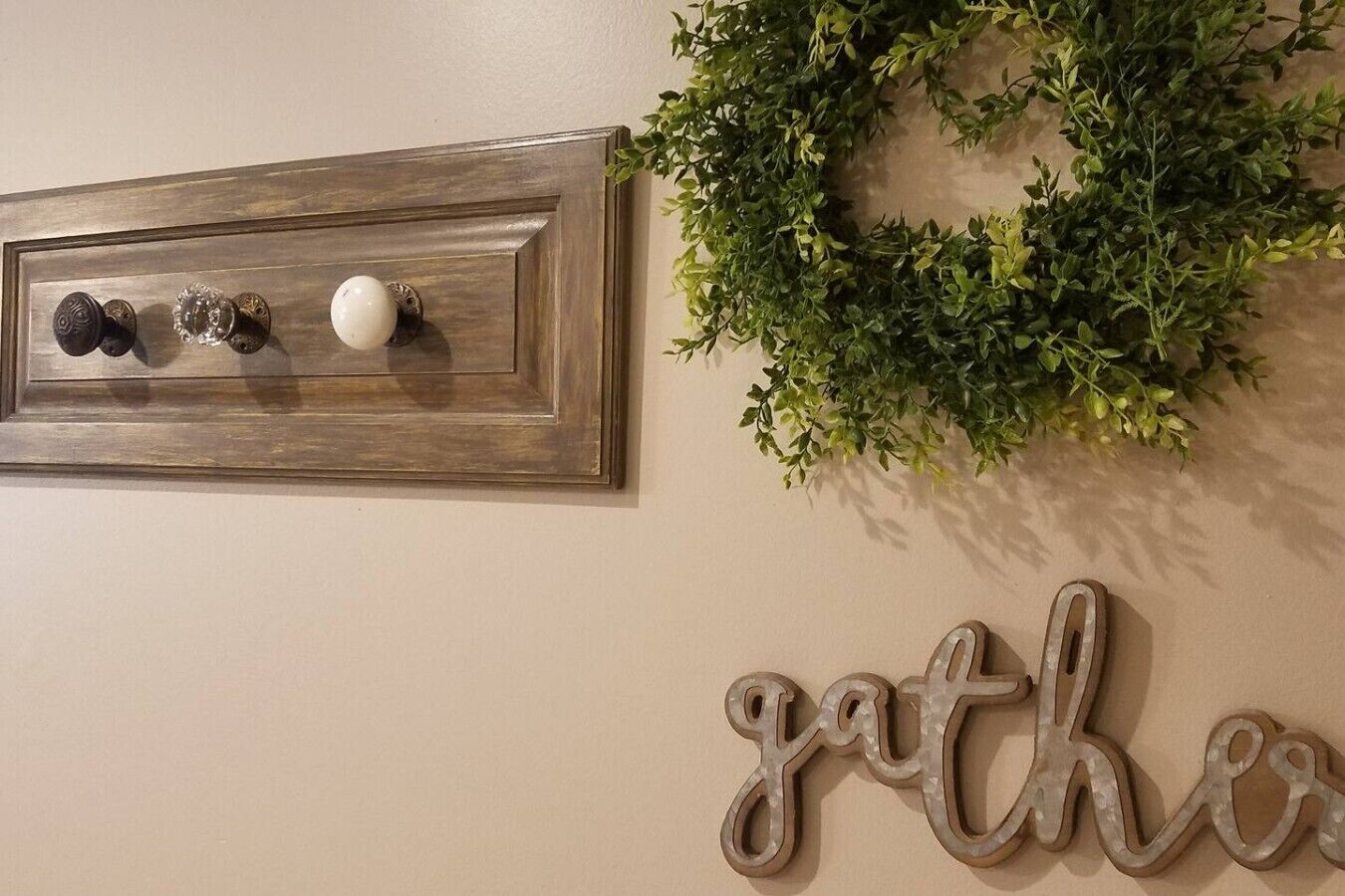 Un mur orné d’une plaque en bois, d’une couronne et du mot « rassemblement » en métal, le tout sur un mur de couleur beige.