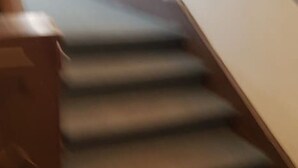A staircase with wooden handrails and carpeted steps.