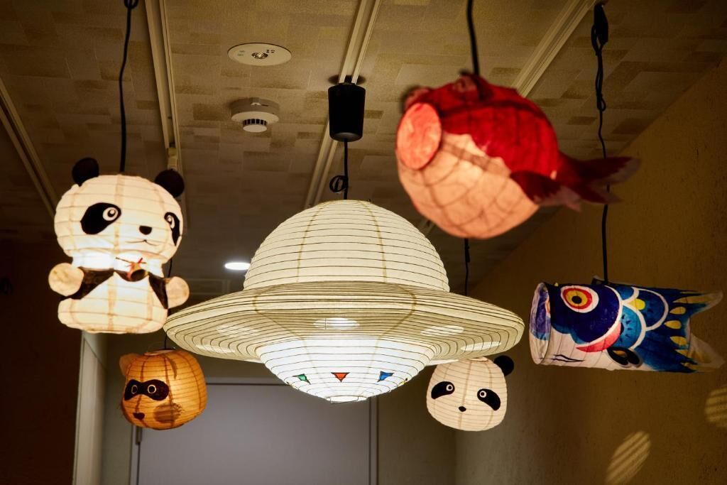 A ceiling with various hanging paper lanterns, including designs of pandas and a fish.