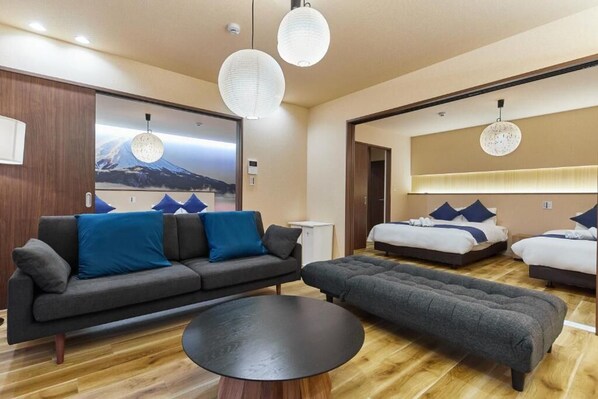 Una habitación de hotel moderna con sofá, reposapiés y cama con almohadas.