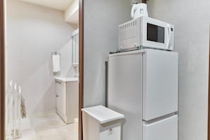 A kitchen with a microwave and a refrigerator.