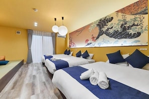 A hotel room with two beds, a large artwork on the wall, and a view of the outside.