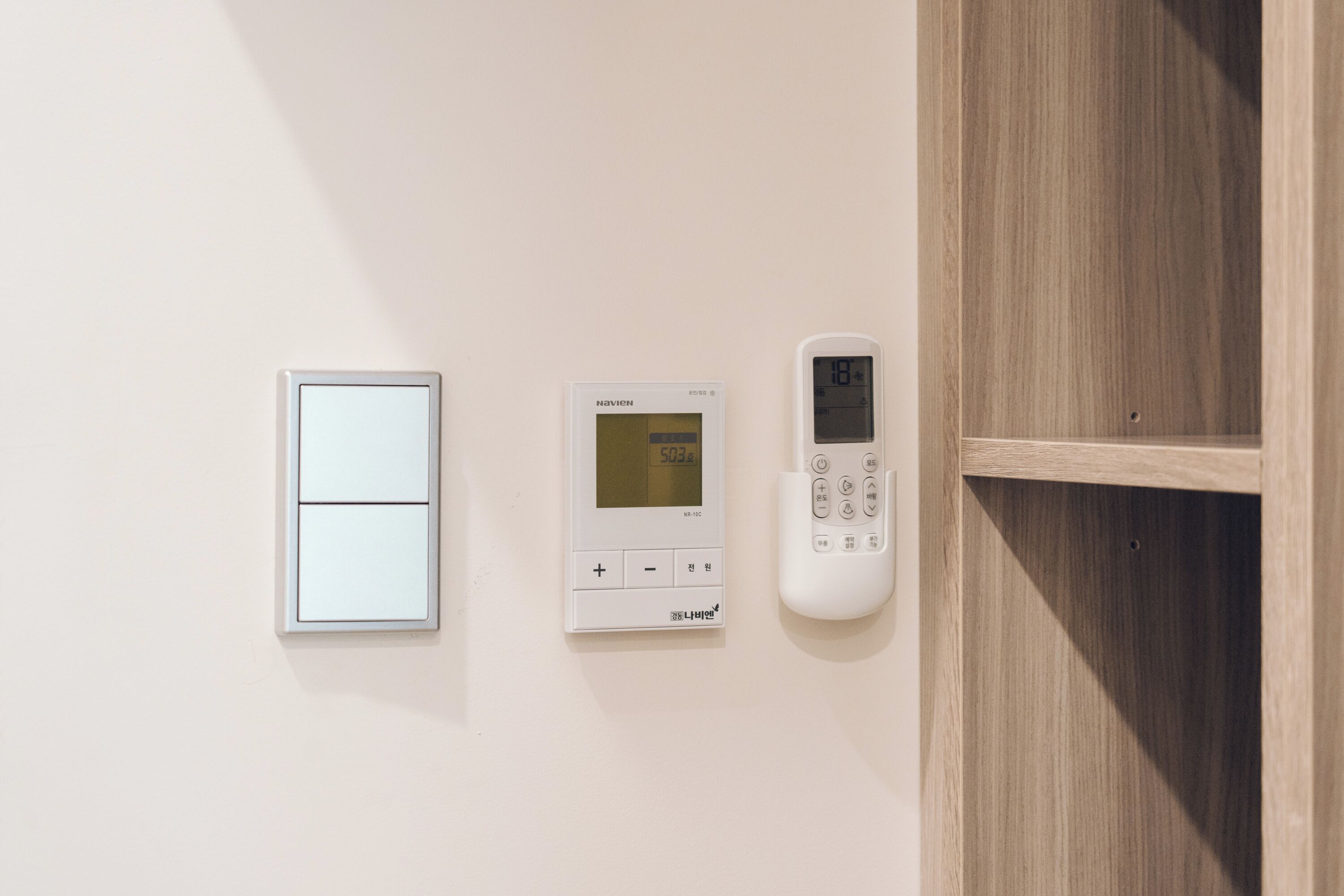 Een thermostaat aan de muur en een deurklink.