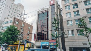 Un immeuble à plusieurs étages, sur lequel on peut voir une grande enseigne indiquant « HÔTEL ».