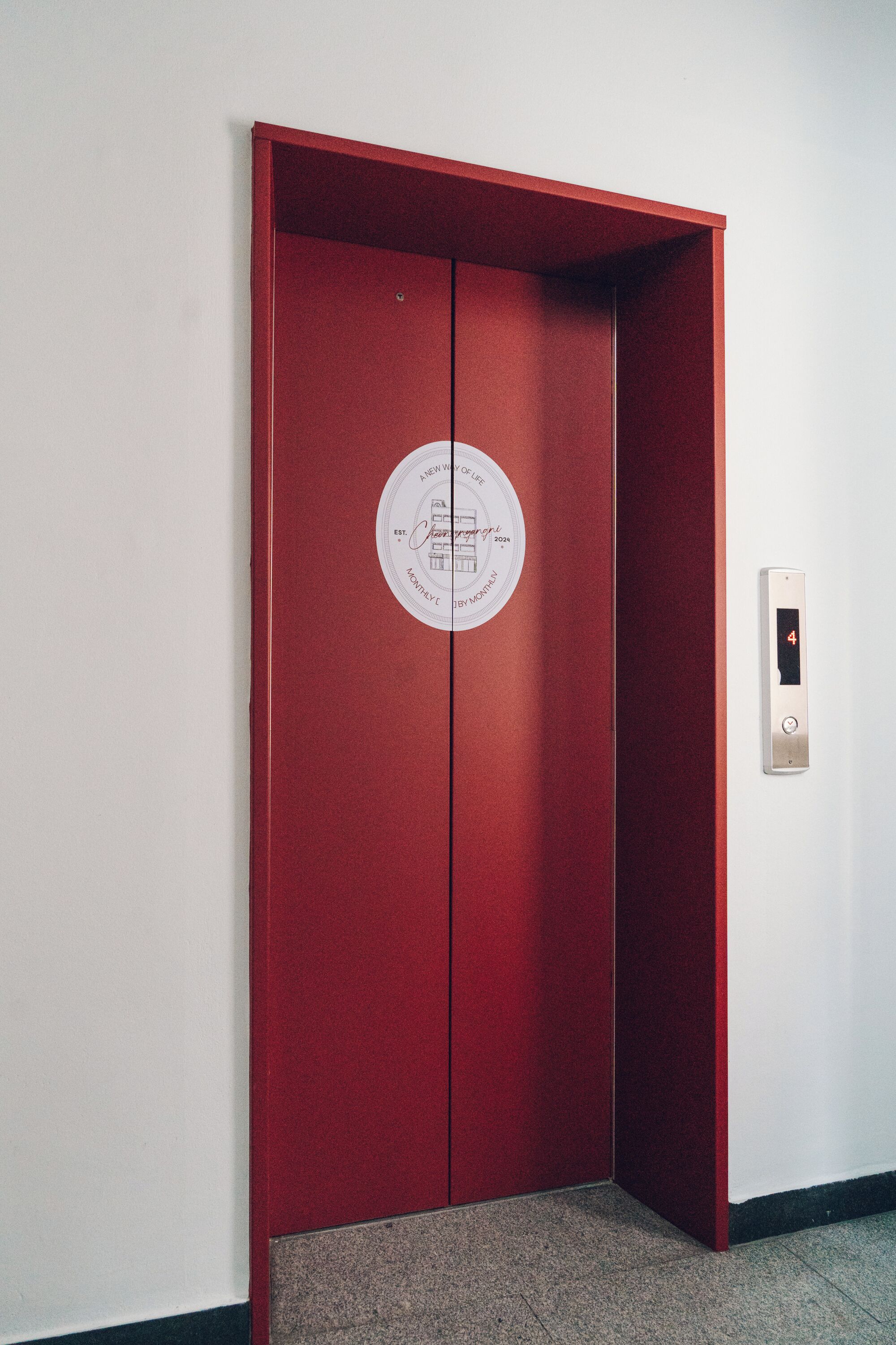 A red elevator with a circular sign on the door.