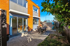 A modern two-story house with a patio area featuring a table and chairs. - Entire home in Christchurch, New Zealand (Christchurch)